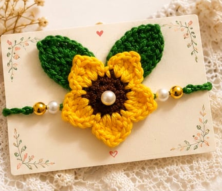 Handmade crochet sunflower rakhi with green leaves, pearl and gold beads